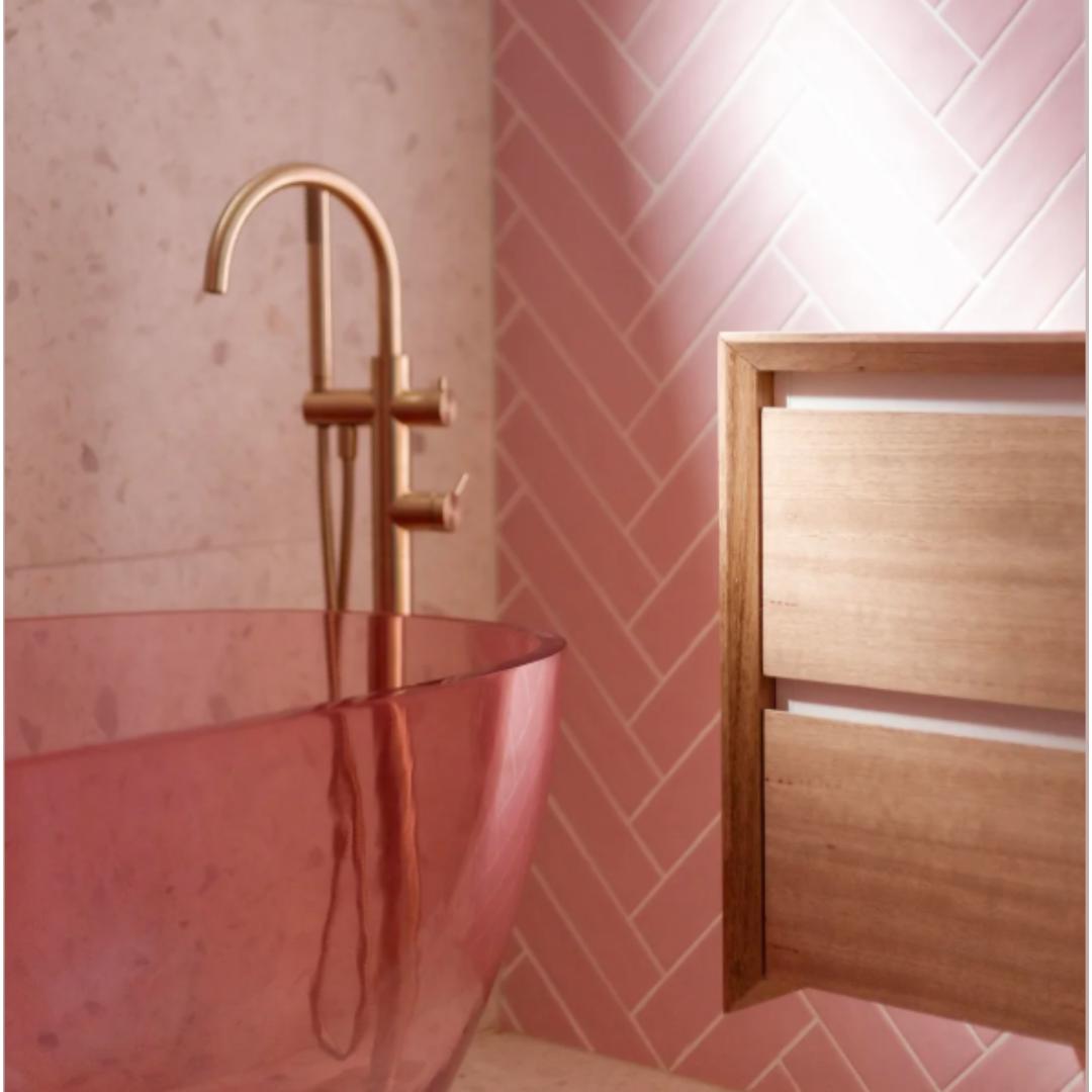 Pink glass sink with gold faucet and wood vanity in a designer bathroom—ideal for boutique bathroom upgrades.